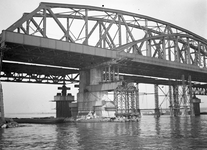 803466 Afbeelding van het invaren van een nieuw brugdeel voor de spoorbrug over de Waal te Nijmegen.
